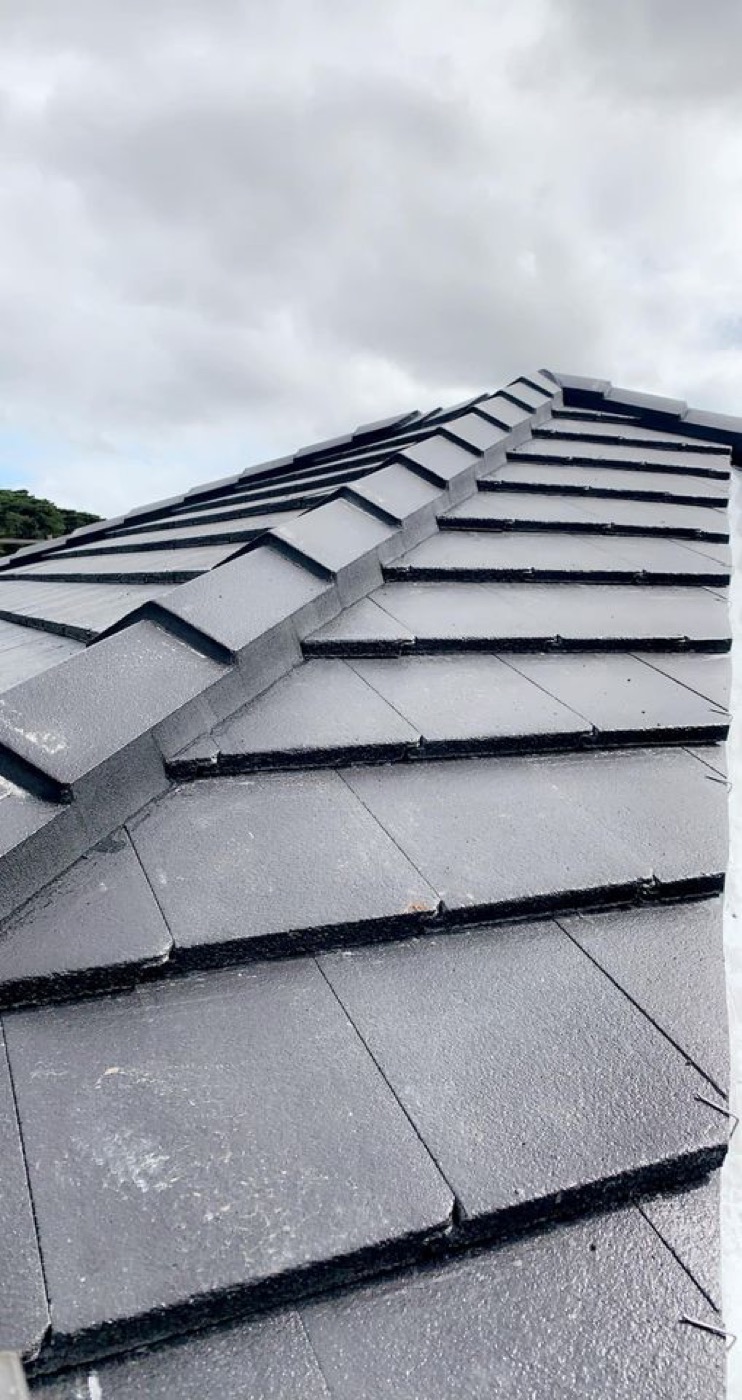 Close-up of new charcoal roof tiles laid in overlapping courses
