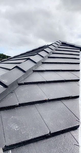 Close-up of new charcoal roof tiles laid in overlapping courses