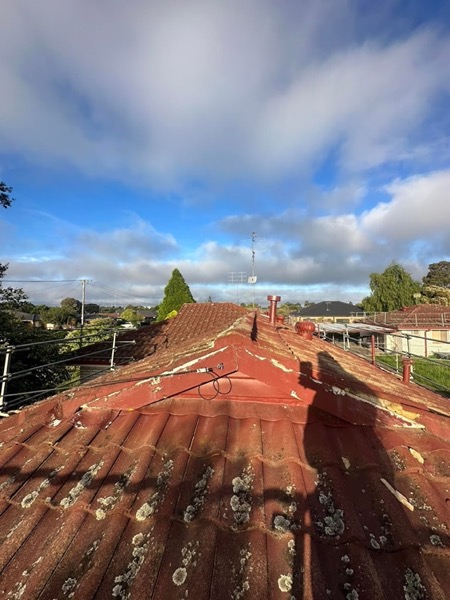 The ridge of an older terracotta roof before restoration work