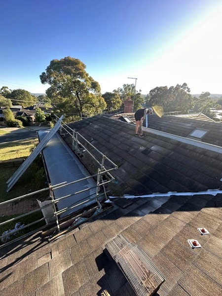 Edge protection rails set up around a roof with a worker on top
