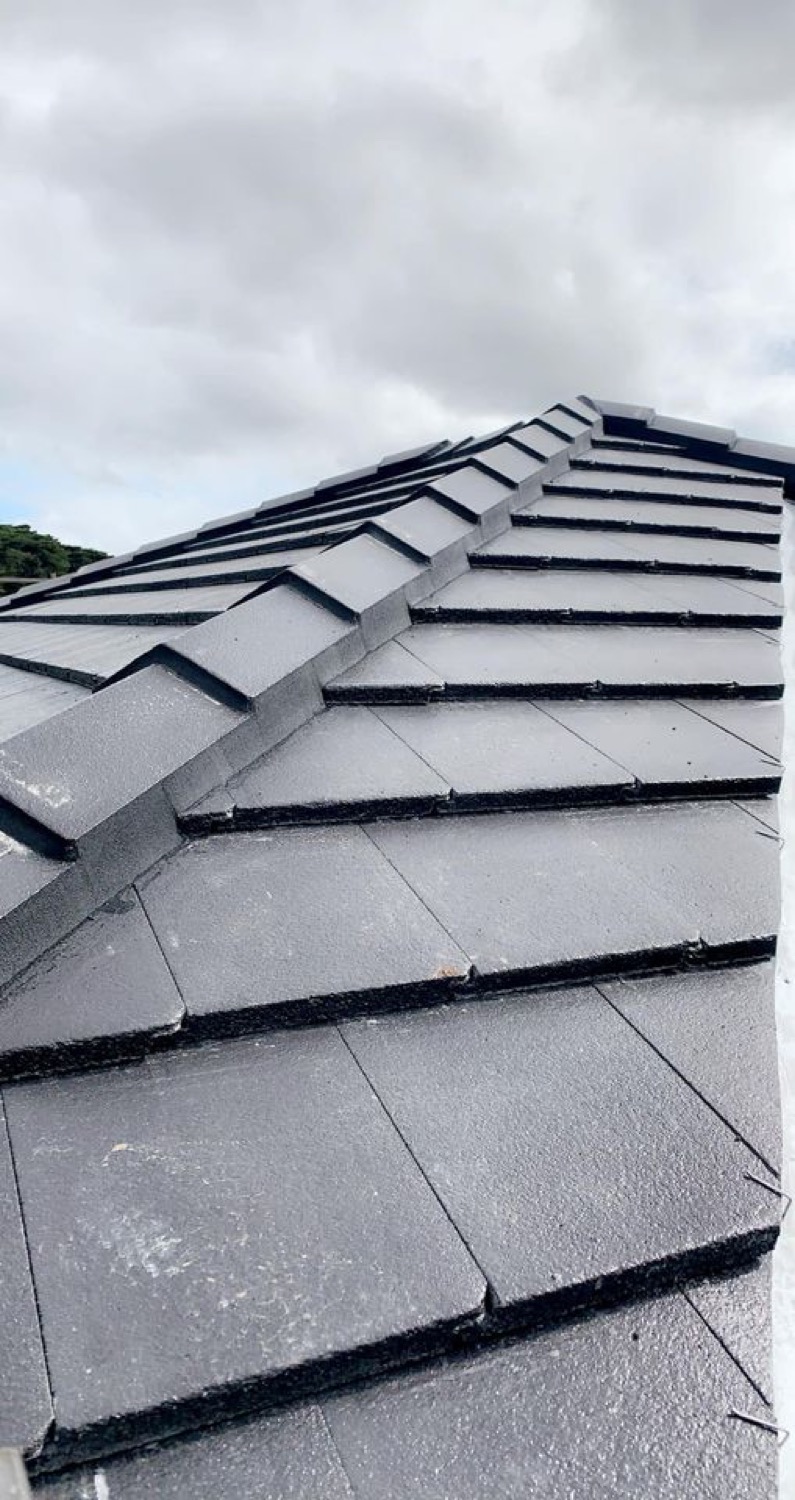 Close-up of new charcoal roof tiles laid in overlapping courses